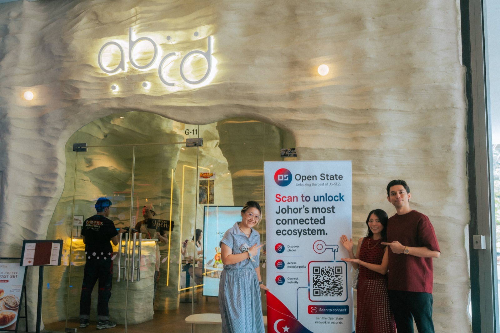 Sekumpulan kecil berdiri di sisi sepanduk Open State di ABCD Cafe.