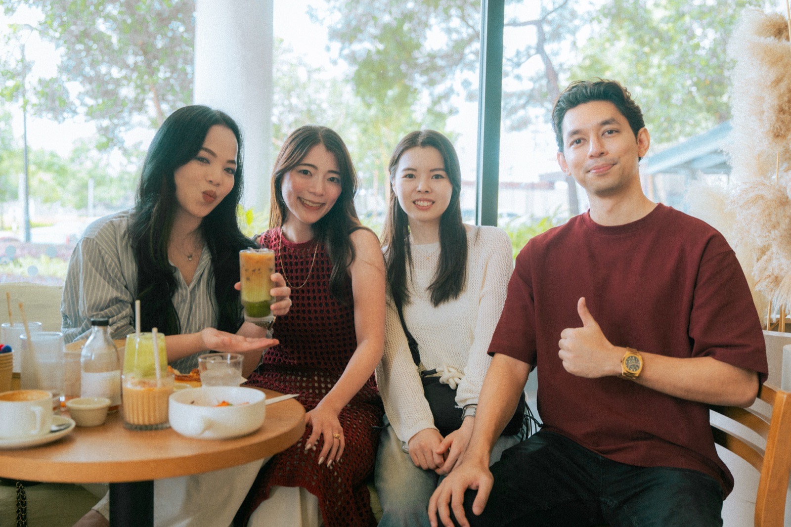 Sekumpulan kecil duduk bersama di meja kafe dengan minuman.
