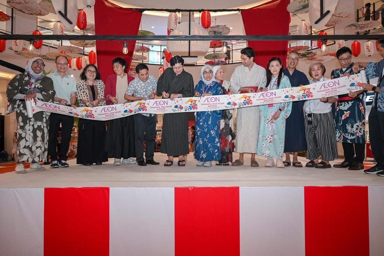 행사 참가자들이 무대에서 Tanabata Bon Odori Matsuri 현수막을 들고 있는 모습.